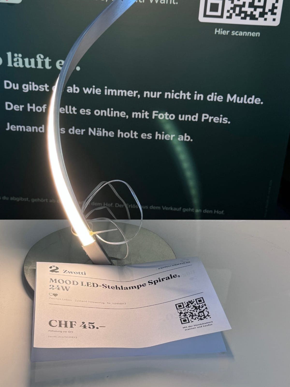 Foto, Schild, online. Eine LED-Stehlampe, erfasst und ausgezeichnet. Wer den QR-Code scannt, kann sie direkt kaufen.